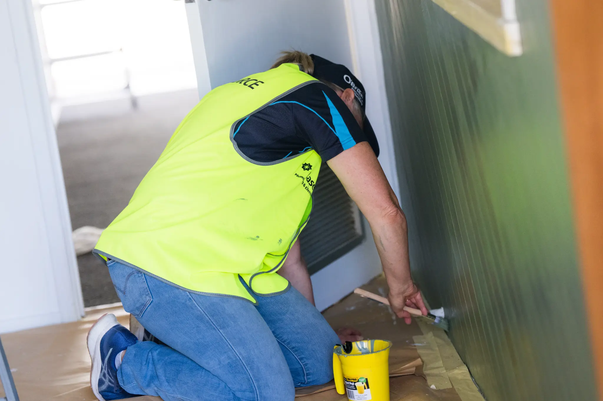 Volunteer painting walls at Maroochy Neighbourhood Centre during O'Brien Taskforce 2025